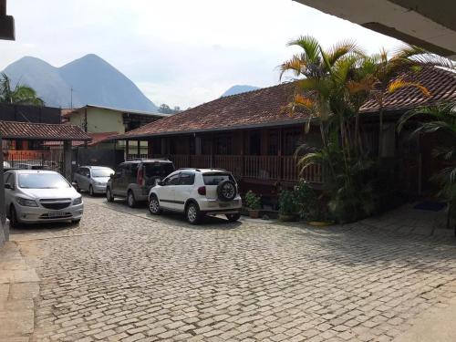 a street with cars parked in front of a building at Hotel Montanus in Nova Friburgo