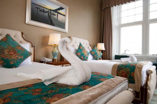 a hotel room with two swans on the beds at The Glenburn Hotel in Rothesay