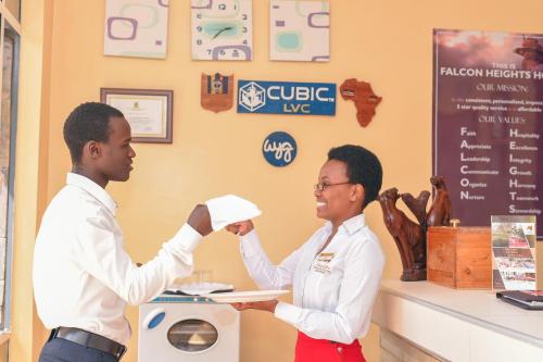 a man and a woman shaking hands at a cash register at Falcon Heights Hotel in Nanyuki