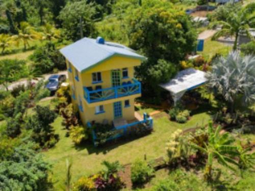 an aerial view of a yellow house with blue trim at Jacoway Inn in Calibishie