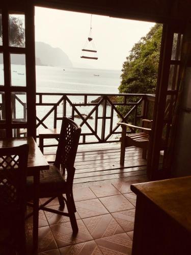 a view of the ocean from a porch with a table and chairs at Alibaba‘s Seabreeze in Castara