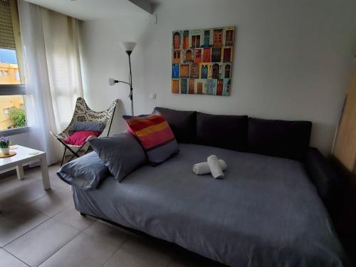 a couch with a teddy bear on it in a living room at Casa Cachita 2-Confortable Estudio a pie de playa in Estepona