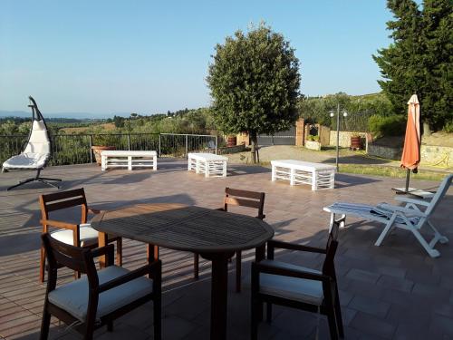 a patio with a table and chairs and an umbrella at Podere Ghiole in Montespertoli