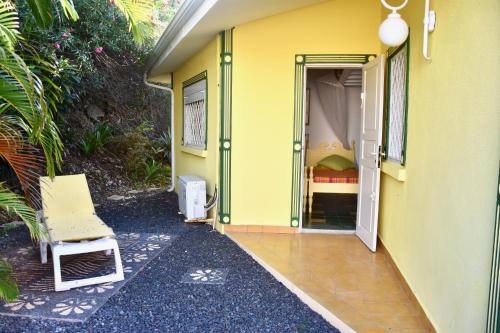 a yellow house with a yellow door and a bed at Villa Guadeloupe Saint François Accès Mer Piscine IGUANA BAY - Villa Zagadi in Saint-François