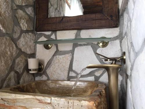 a stone bathroom with a sink and a mirror at Casa Lisetta in Villa D'agri