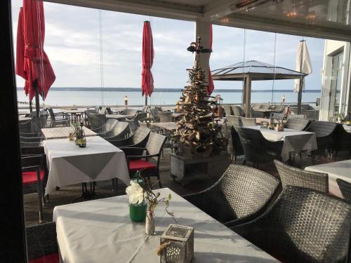 a restaurant with tables and chairs and a christmas tree at Der LeuchtTurm-Gastro GmbH in Geierswalde