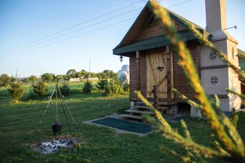 a small house with a swing in a yard at Agronoclegi ,,Na Równi" 535-950-405 in Mchawa