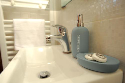 Zen & Geo's HOME في سلانيك: مغسلة الحمام عليها زجاجة صابون
