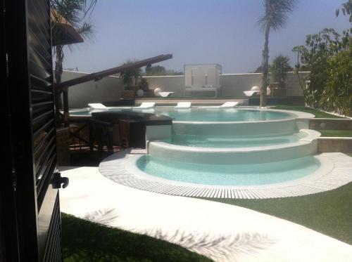 a swimming pool in a yard with a patio at Villa Campito in El Puerto de Santa María