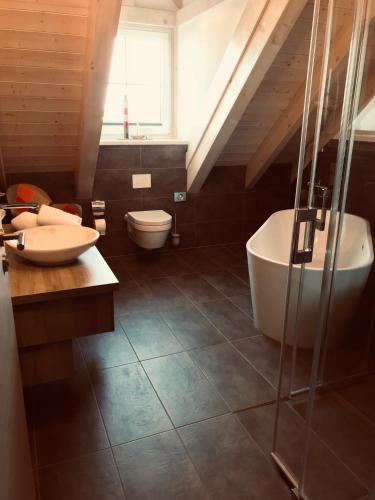 a bathroom with a tub and a toilet and a sink at Der LeuchtTurm-Gastro GmbH in Geierswalde