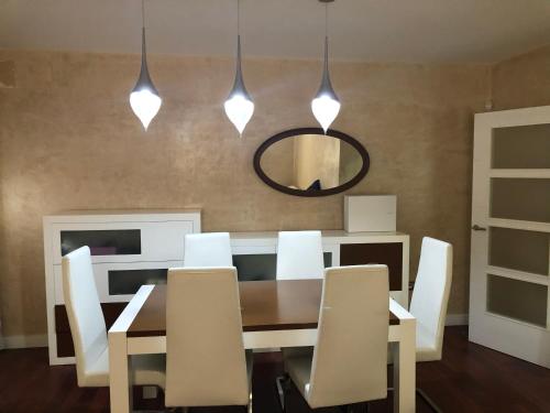 a dining room with a table and chairs and a mirror at Villa Campito in El Puerto de Santa María