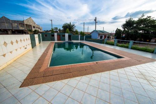 a swimming pool on a tiled patio at Pemicsa Hotel Accra in Spintex
