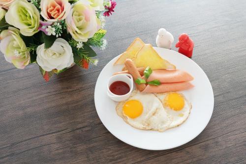 a plate of breakfast food with eggs and toast at NK Residence Sakon Nakhon in Sakon Nakhon