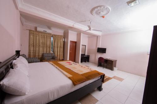 a bedroom with a bed and a desk in it at Pemicsa Hotel Accra in Spintex