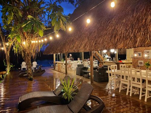 a restaurant with chairs and tables and a straw roof at Boatique Hotel and Marina in Rio Dulce