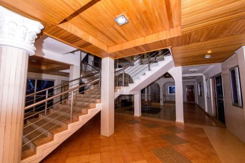 a staircase in a building with a wooden ceiling at Pemicsa Hotel Accra in Spintex