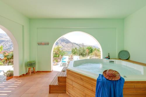 baño grande con bañera de hidromasaje y 2 ventanas arqueadas en Villa Kallisti - Artemis en Kávallos