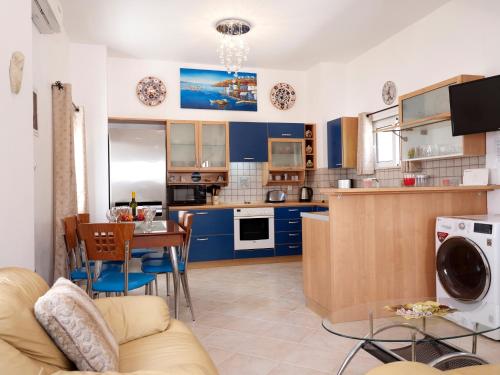 a living room and kitchen with blue cabinets and a table at Haraki Beach Mediterranean Retreat in Haraki