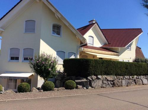 a large white house with a stone retaining wall at Ferienwohnung Kunst in Mahlberg