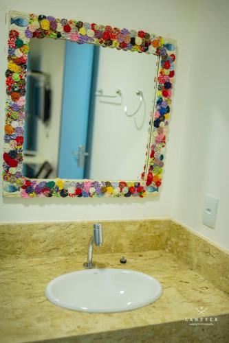 a bathroom with a sink and a mirror at Suítes Da Vila 152 in Praia do Forte