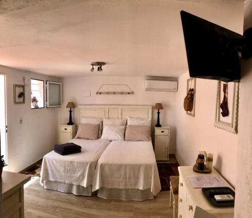 エステポナにあるEstudio a 10 minutos del Puerto Banusのベッドルーム(白いベッド1台、薄型テレビ付)