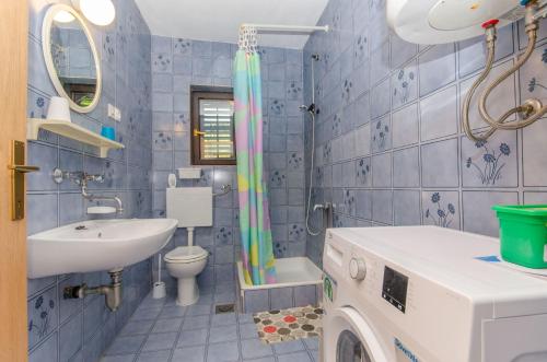 La salle de bains est pourvue d'un lavabo, de toilettes et d'une douche. dans l'établissement Apartment Vitaic, à Supetar