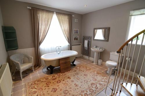 a bathroom with a tub and a toilet and a sink at The Woodlands in Sandsend