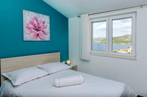 a bedroom with a large bed with a window at Apartments Katic in Ražanj