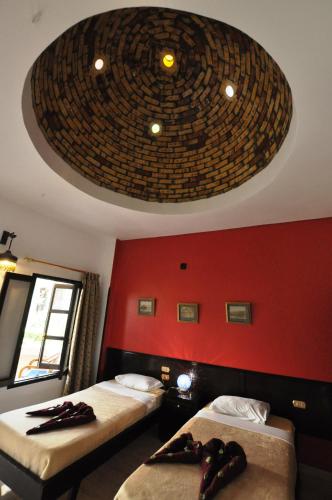 a room with two beds and a large ceiling at El Nakhil Hotel in Luxor