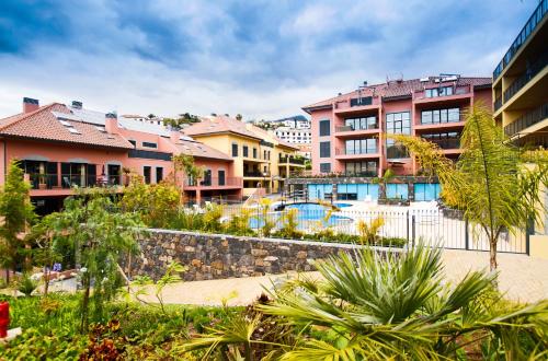 um grupo de edifícios de apartamentos com piscina e árvores em Madeira Luxury Villas Living Funchal no Funchal