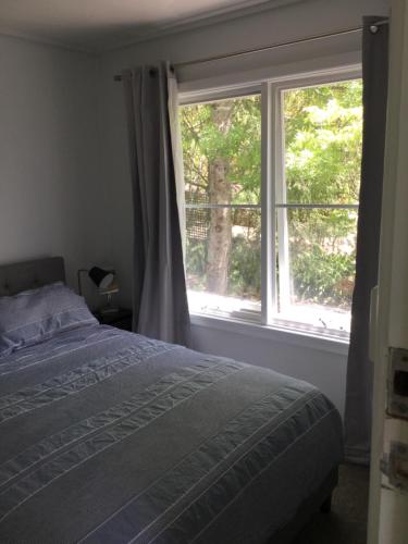 a bedroom with a bed and a large window at The Wentworth Retreat in Wentworth Falls