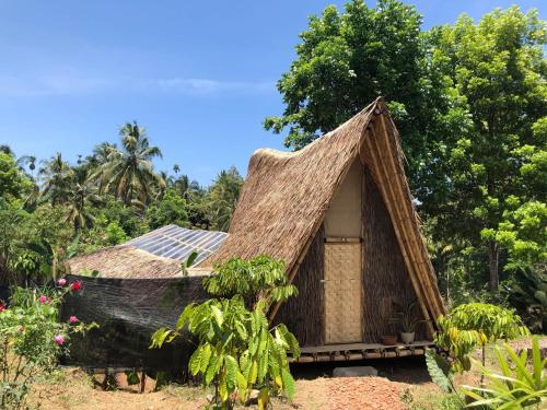 a small hut with a grass roof at Bamboo & B in Licin