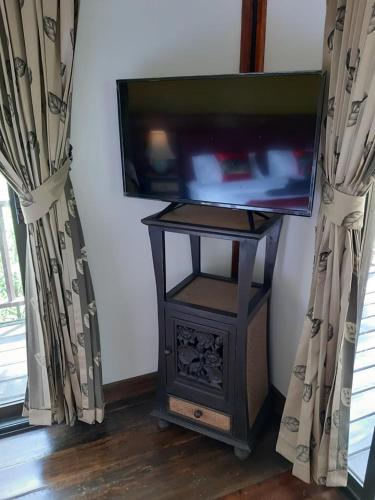 a television on a stand in a room with curtains at Little Rock Kohjum in Ko Jum