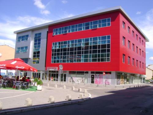 a red building with people sitting outside of it at Hotel Vidović in Banja Luka