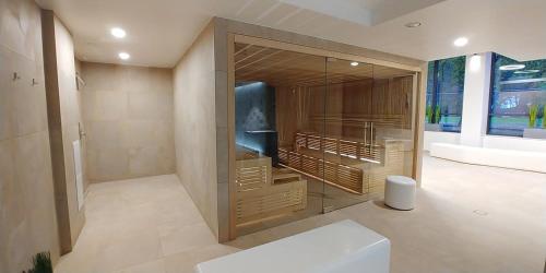 uma casa de banho com um grande armário de vidro e uma banheira em Bodnar Apartamenty Nadmorskie Tarasy Port em Colberga
