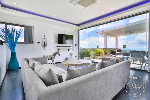 a living room with a large couch and a large window at Villa Azur, 4 Bedrooms, Ocean View in Chaweng