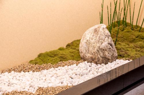 a rock sitting on top of moss and gravel at Dormy Inn Kawasaki Natural Hot Spring in Kawasaki