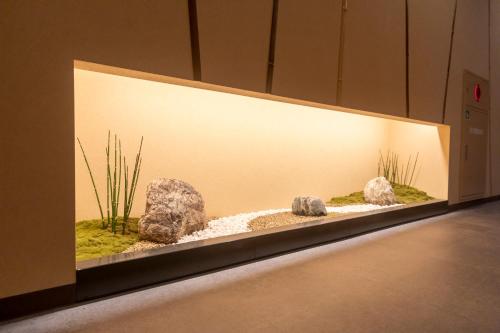 a large aquarium with rocks and plants in it at Dormy Inn Kawasaki Natural Hot Spring in Kawasaki