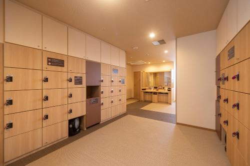 a locker room with wooden lockers and a kitchen at Dormy Inn Kawasaki Natural Hot Spring in Kawasaki