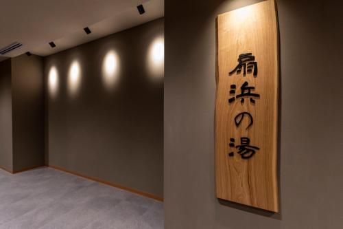 a wall with a sign with asian writing on it at Dormy Inn Kawasaki Natural Hot Spring in Kawasaki