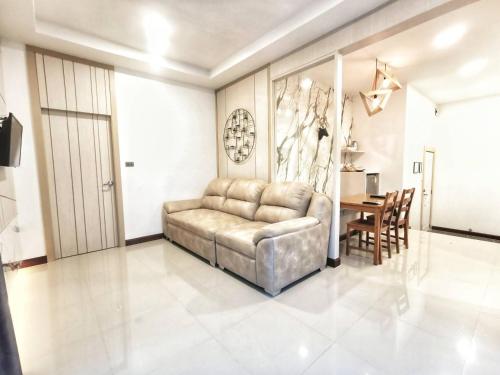 a living room with a couch and a table at The Vista Pool Villa in Kanchanaburi