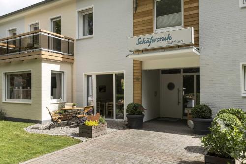a building with a patio with a table in front of it at Gaestehaus Schaefersruh in Haffkrug