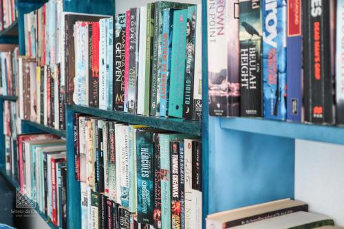 a book shelf filled with lots of books at Apartamentos Sereia da Oura in Albufeira