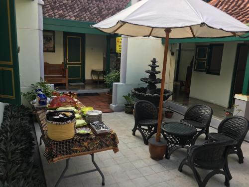 un tavolo con ombrellone su un patio di Pamularsih Homestay a Yogyakarta