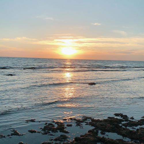 a sunset over the ocean with the sun setting at Coral Island in Xiaoliuqiu
