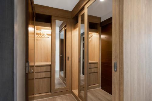 a walk in closet with wooden cabinets and mirrors at Reiz - Private Residence in Chiang Mai