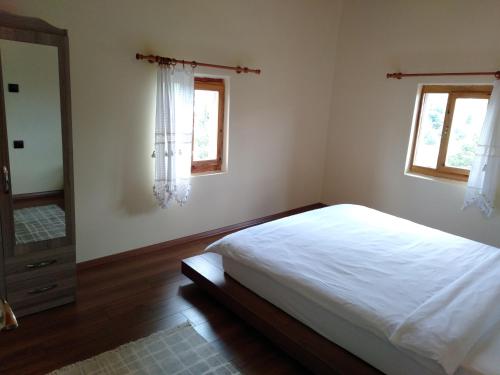 1 dormitorio con 1 cama blanca y 2 ventanas en TAŞ KONAK BUTİK OTEL, en Ordu