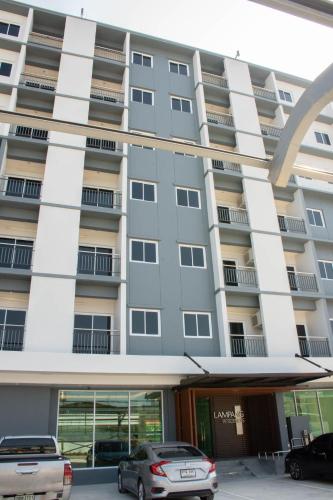a building with cars parked in front of it at Lampang Residence in Lampang