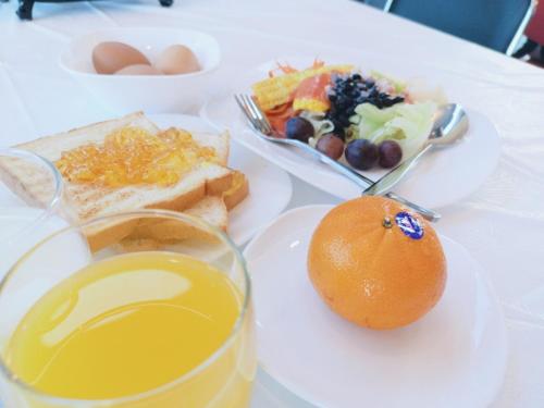 a table with plates of food and an orange on it at Lampang Residence in Lampang