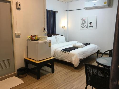 a small room with a bed and a table with a refrigerator at T&N home Ayutthaya in Phra Nakhon Si Ayutthaya